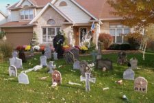 17 graveyard decor with a witch figure standing next to it will turn your entrance into a spooky one