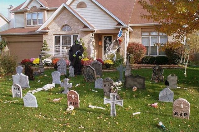 graveyard decor with a witch figure standing next to it will turn your entrance into a spooky one