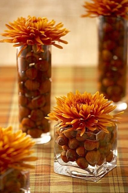 vases and jars filled with hazelnuts and bold orange flowers