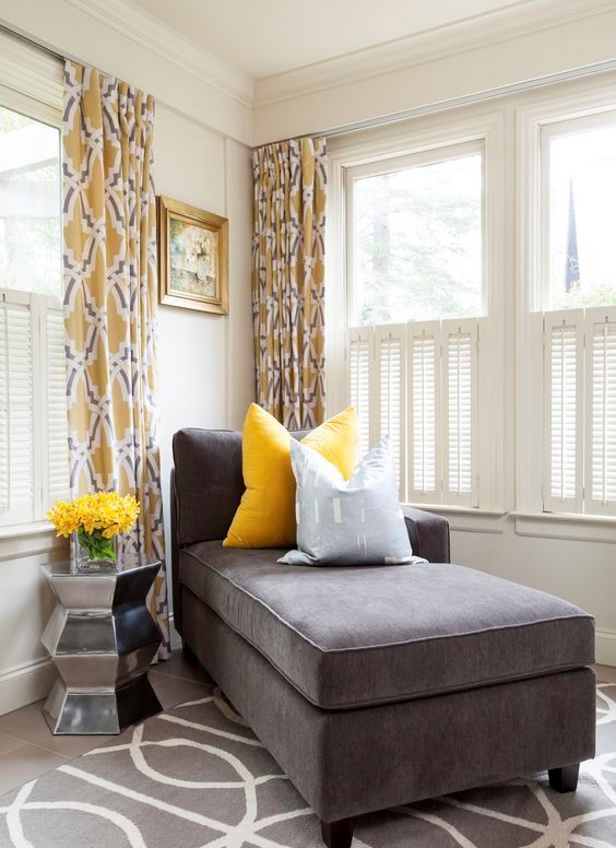 a charcoal couch and a bold yellow pillow look very contrasting