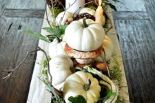 22 centerpiece with white pumpkins, moss, leaves and candles is refreshing