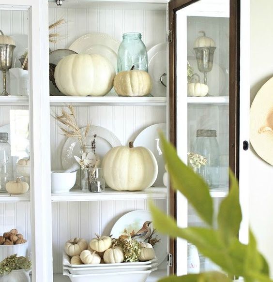 place neutral pumpkins and wheat into your glass kitchen cabinet