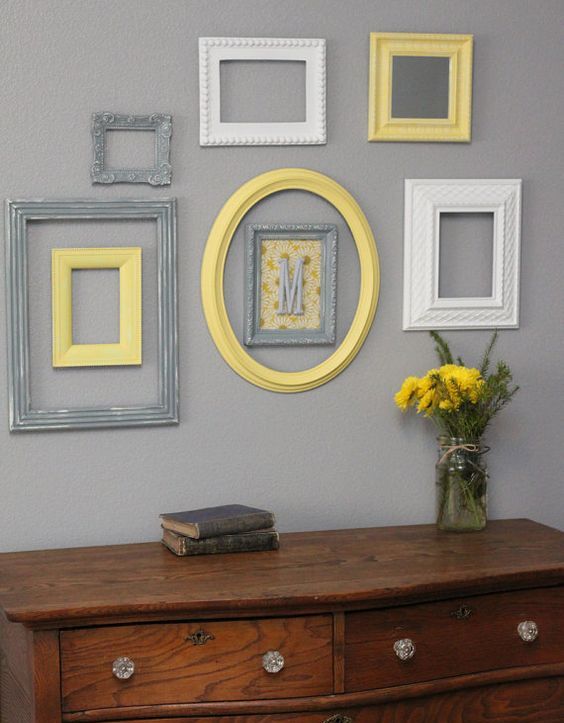 cream, grey and yellow frames on a light grey wall