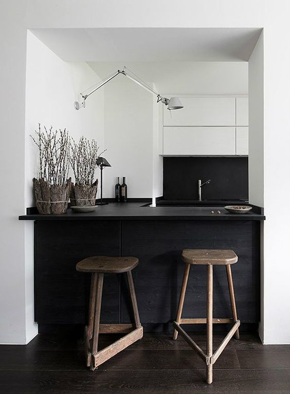 small minimal black and white kitchen with a kitchen island and dining space in one