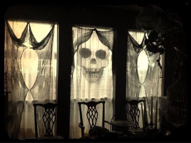 use black cheese cloth as spooky yet classy curtains for Halloween decorations