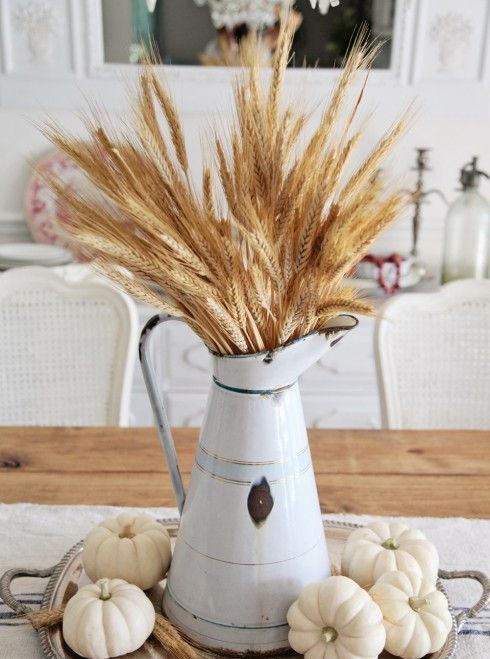 harvest centerpiece with white pumpkins and wheat in a vintage pitcher