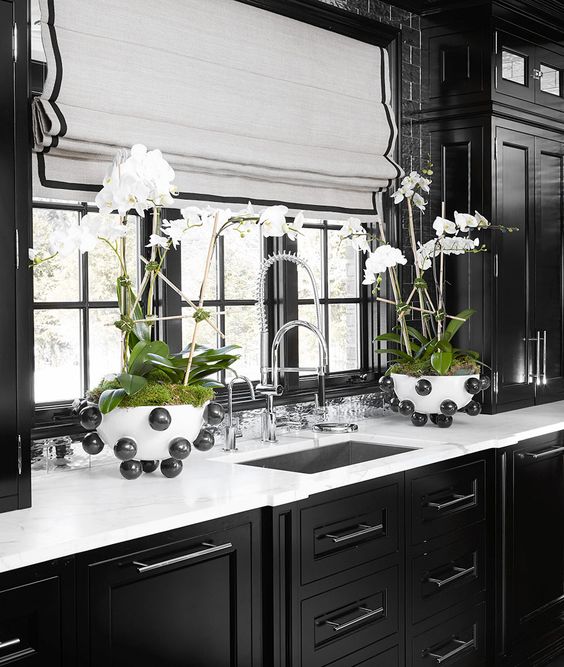 orchids in moss add a luxurious touch to this traditional dark moody kitchen