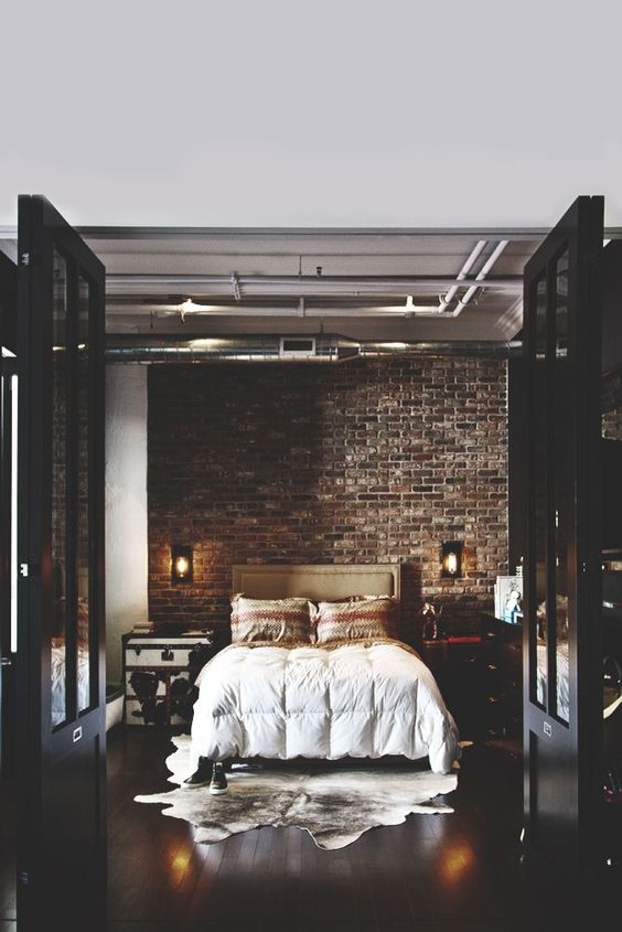 chic moody bedroom becomes luxurious thanks to the dark bricks