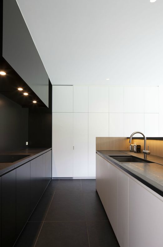 kitchen with a white and a black half and lights to keep the space luminous