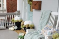 35 white pumpkins, a white rocker and a pastel blanket and pillow