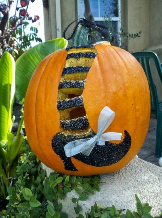witch leg with glitter and a bow on a pumpkin