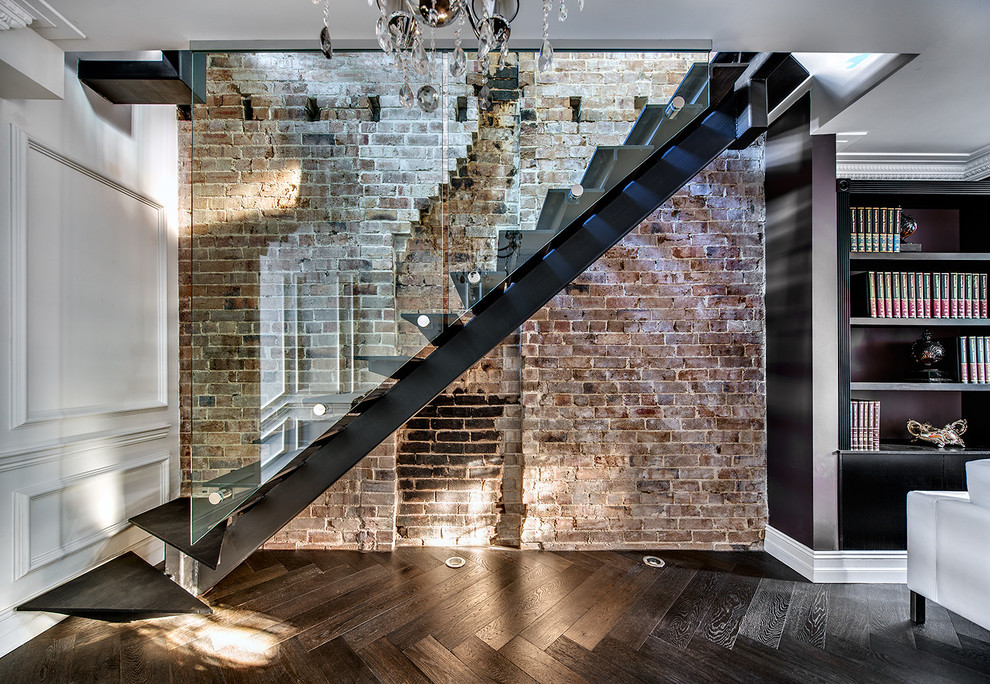 a modern staircase made of glass and metal would look great against a really rough wall made of damaged bricks