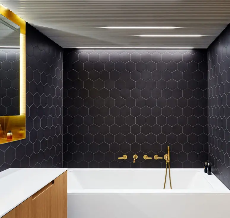 This modern bathroom is done in black, white and brass for an elegant and laconic look