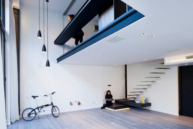 A floating stairs gives this space a unique modern look, and double-height ceilings are highlighted with pendant lamps