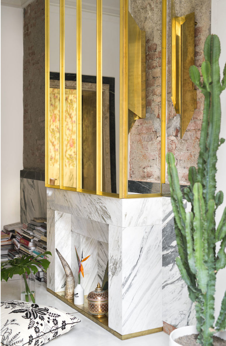 Carrara marble is one of the luxurious materials used throughout the house, and it works well with a gilded framed mirror