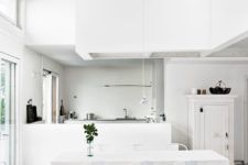 02 The kitchen is white and serene, it gets an advantage from the double-height windows, they show the patio and bring much light in