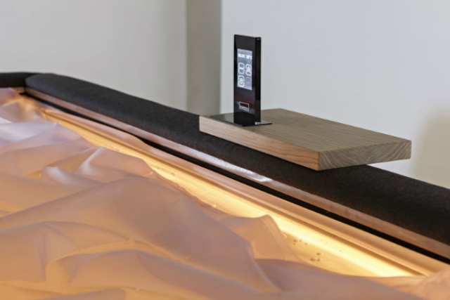 The piece has a comfy caddy for gadgets and lights that remind of bathtubs filled with water