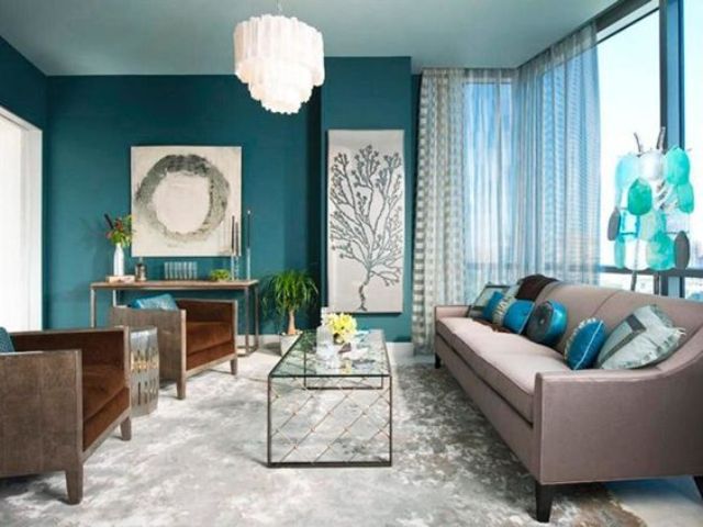 a teal accent wall, aqua blue accessories and brown upholstered furniture