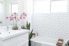 a mid-century modern bathroom with white subway tiles on the walls and black hexagon ones on the floor that work nice with each other