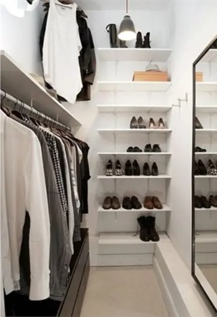 perfect minimalist closet layout with a leading rack on one wall, a mirror on the opposite wall and shoe shelves on the third one