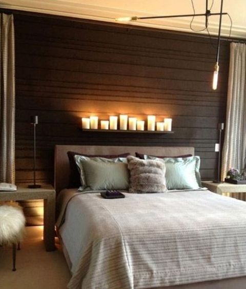 small LED lamps and pillar candles on the shelf above the bed