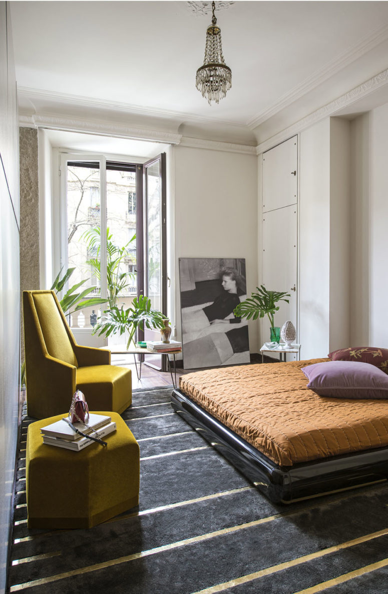 The bedroom surprises with geometric furniture, a sleek black bed on the floor and bold textiles