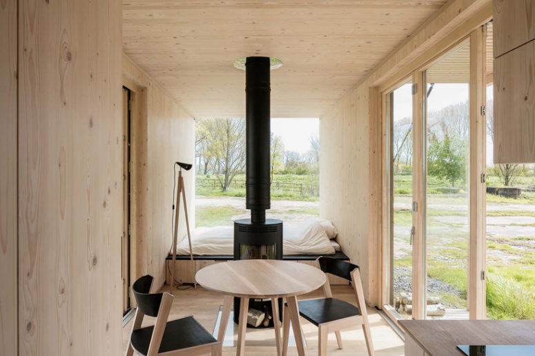 The inside is clad with light-colored warm woods to make it natural and cozy, and the furniture is contrasting black