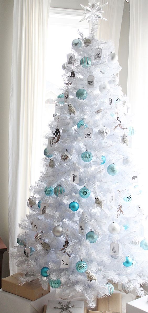 crispy white christmas tree decorated in blue and silver breathes with frost