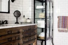 a rustic meets industrial bathroom with white subway tiles on the walls and large scale tiles on the floor, with black touches and fixtures