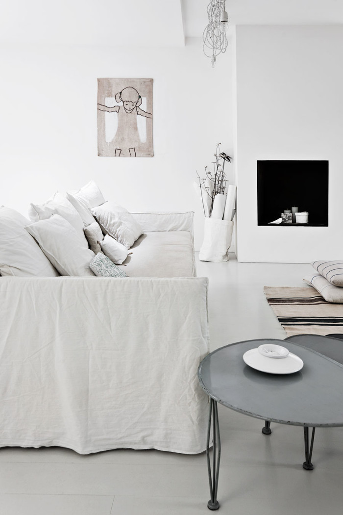 The living room is Scandi classics, with a faux fireplace, rough white textiles and even burlap