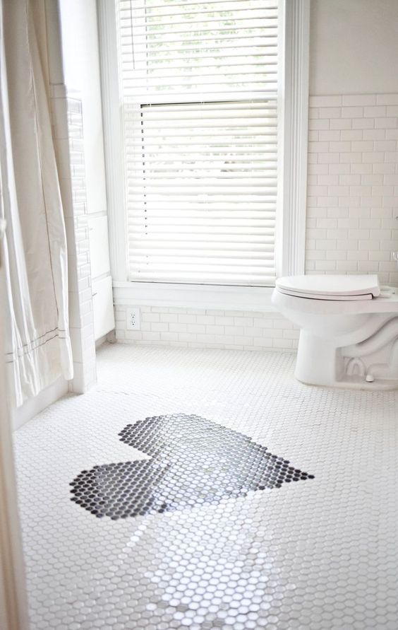crisp and clean white bathroom redo with subway tiles and a heart on the penny tile floor