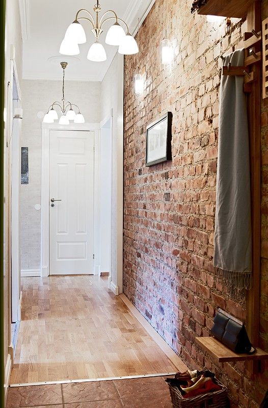 narrow entryway with a brick wall that adds texture