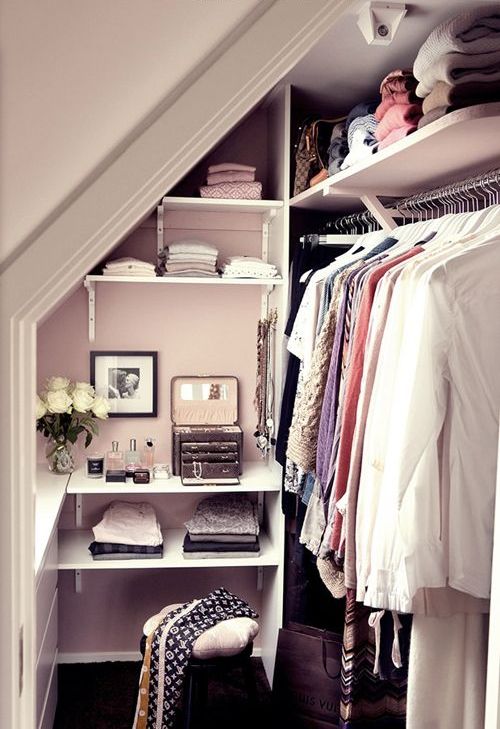 tiny walk-in closet with a leading rack on the right and open shelving in the center
