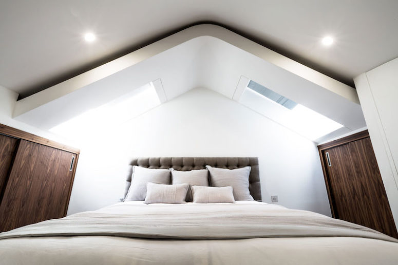 The bedroom features an attic roof with windows and a mix of chocolate brown and white