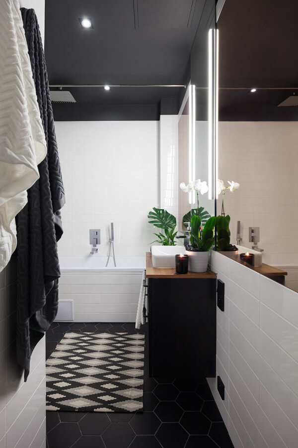 The simple and timeless black and white bathroom is accentuated with potted orchids