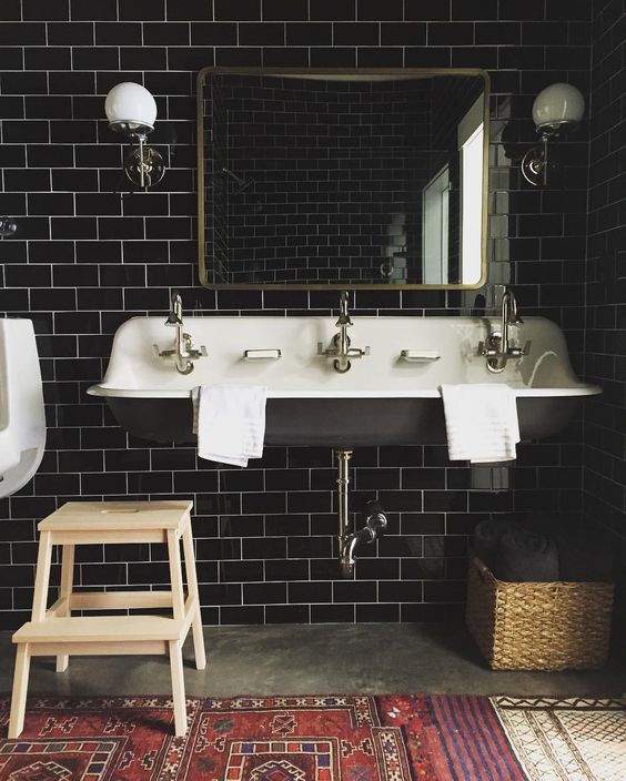 black subway tiles become a perfect backdrop and create a mood in this bathroom, a vintage sink continues with the style