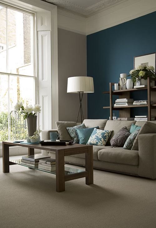 grey and beige room with a teal accent wall, blue pillows and accessories