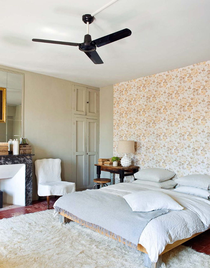 Another bedroom is pastel and full of light with pretty printed wallpaper and a fluffy carpet