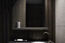 08 modern bathroom space with dark wood panels, a black marble counter and a large mirror