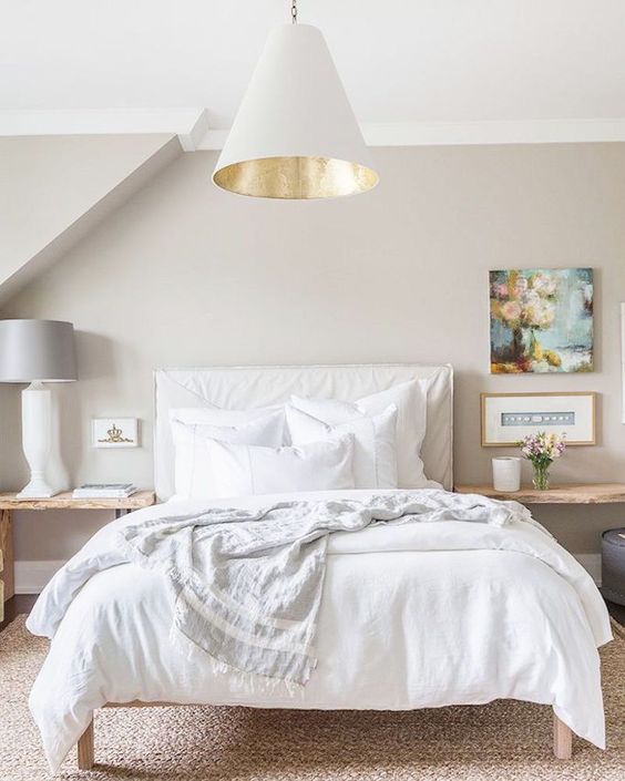 cozy bed with neutral bedding and pillows looks welcoming