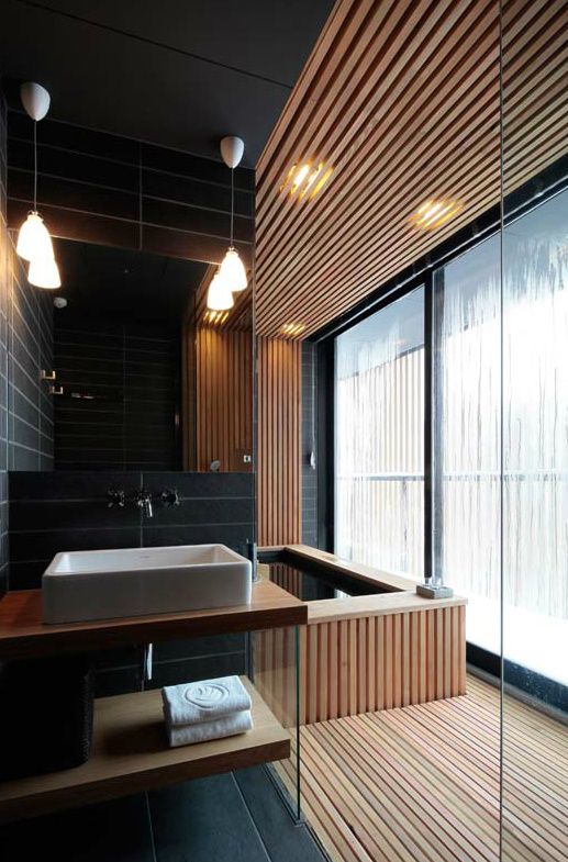 sensual bathing area with black tiles and light wood slabs that keep the space minimalist yet very luxurious