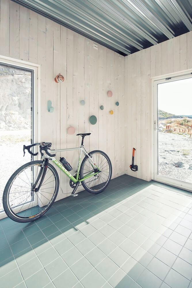 The entryway has a lot of light in due to a glass door and it features a bike stand