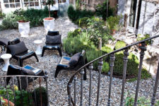 11 The small garden looks like a heaven with herbs and lavender in antique pots and modern black chairs