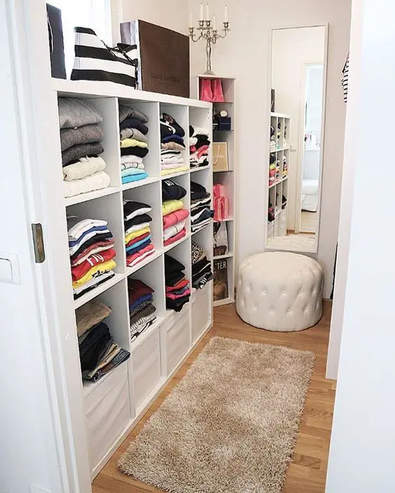 a mirror in the center, open rack for clothes on the other sides