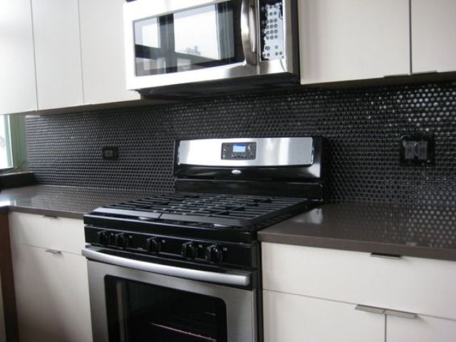 glossy black penny tiles for a minimalist black and white kitchen