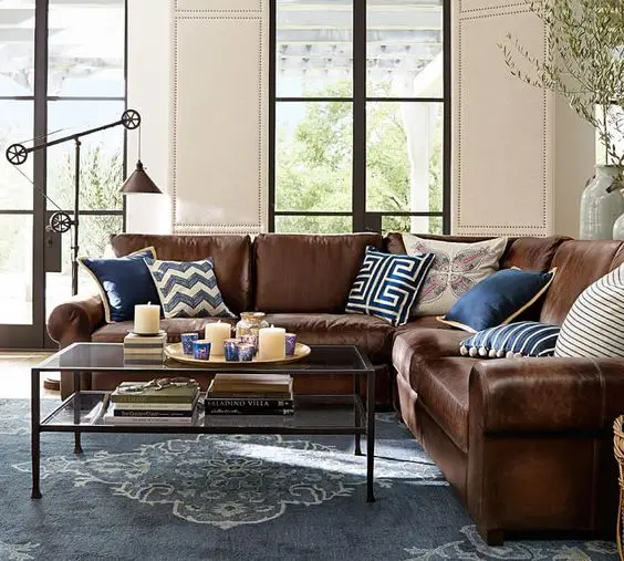 L shaped brown leather sofa looks great and refreshed with navy and blue pillows