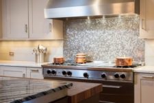 12 glowing silver penny tile backsplash looks great with a stainless steel hood