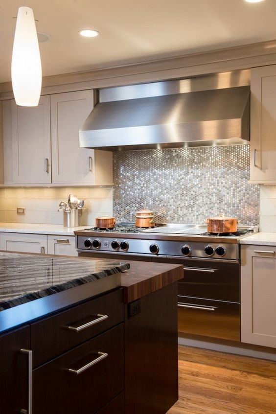 glowing silver penny tile backsplash looks great with a stainless steel hood