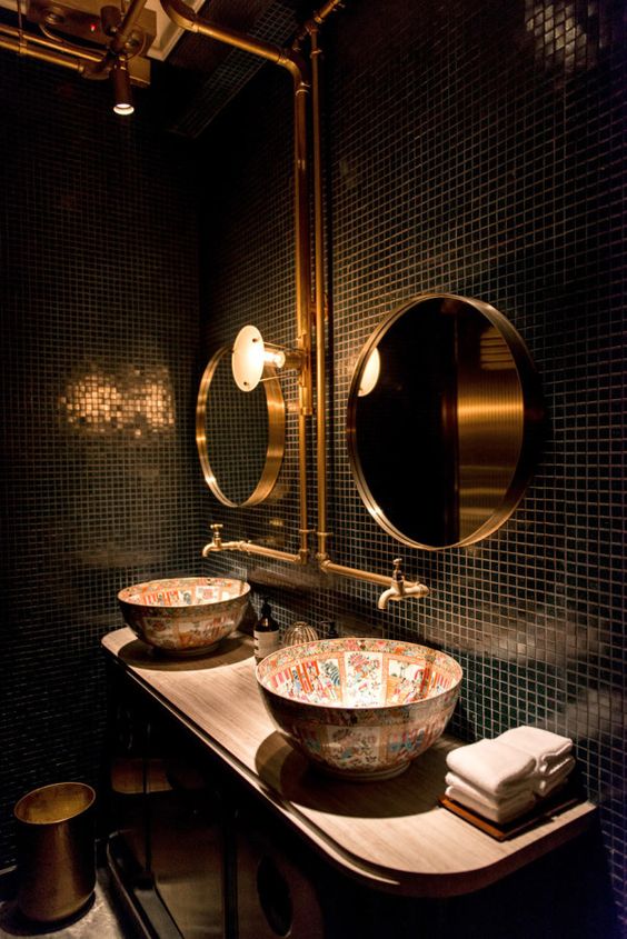 small black tiles, brass details and unique patterned sinks