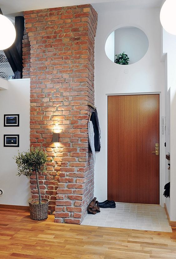 large brick pillar gives a stylish look to both the entryway and the kitchen next to it